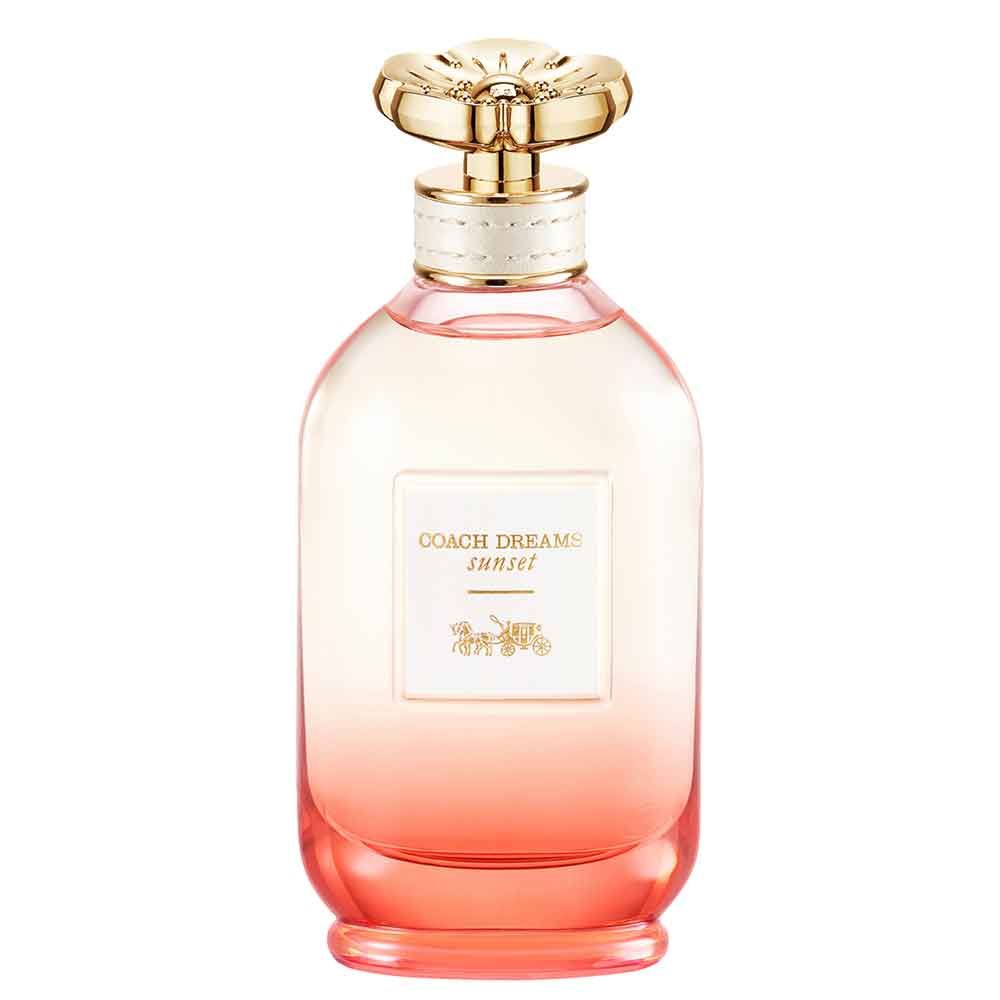 Parfümflakon mit goldfarbenem Deckel. Aufkleber mit "Coach Dreams Sunset" und Kutschen-Logo. Farbverlauf von rosa nach orange.