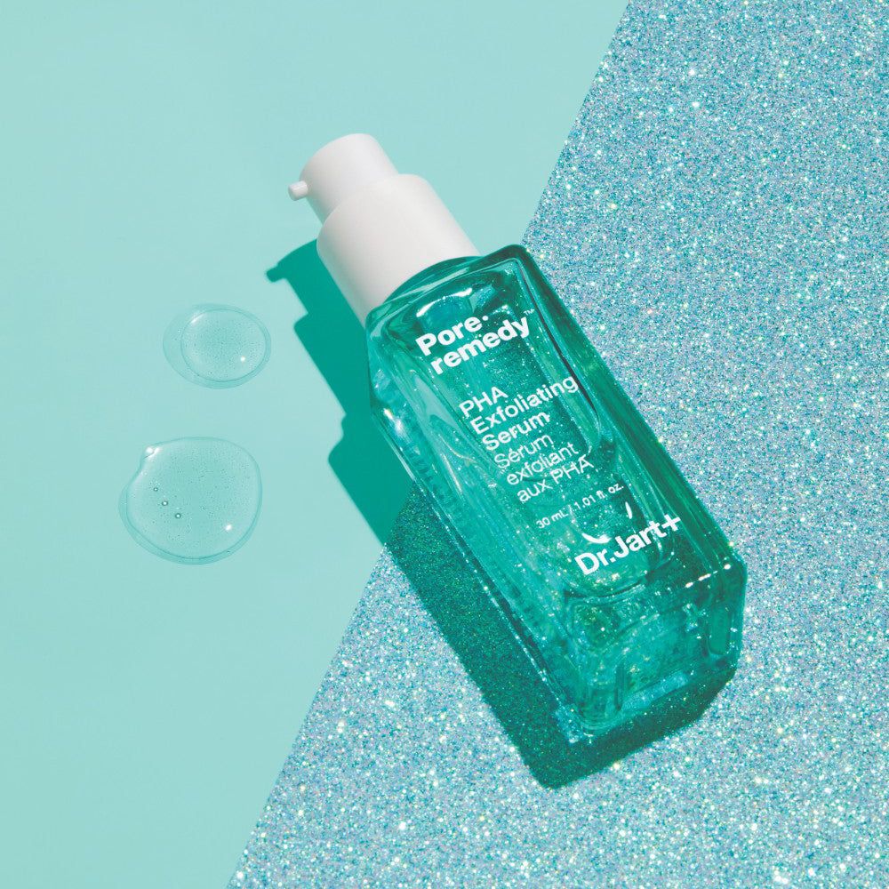 Serumflasche auf glitzerndem Hintergrund. Text: Pore·remedy, PHA Exfoliating Serum, Dr.Jart+.
