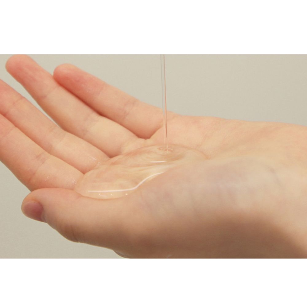 Transparente Flüssigkeit auf einer Handfläche. Produkt wird aus einer nicht sichtbaren Quelle gegossen.