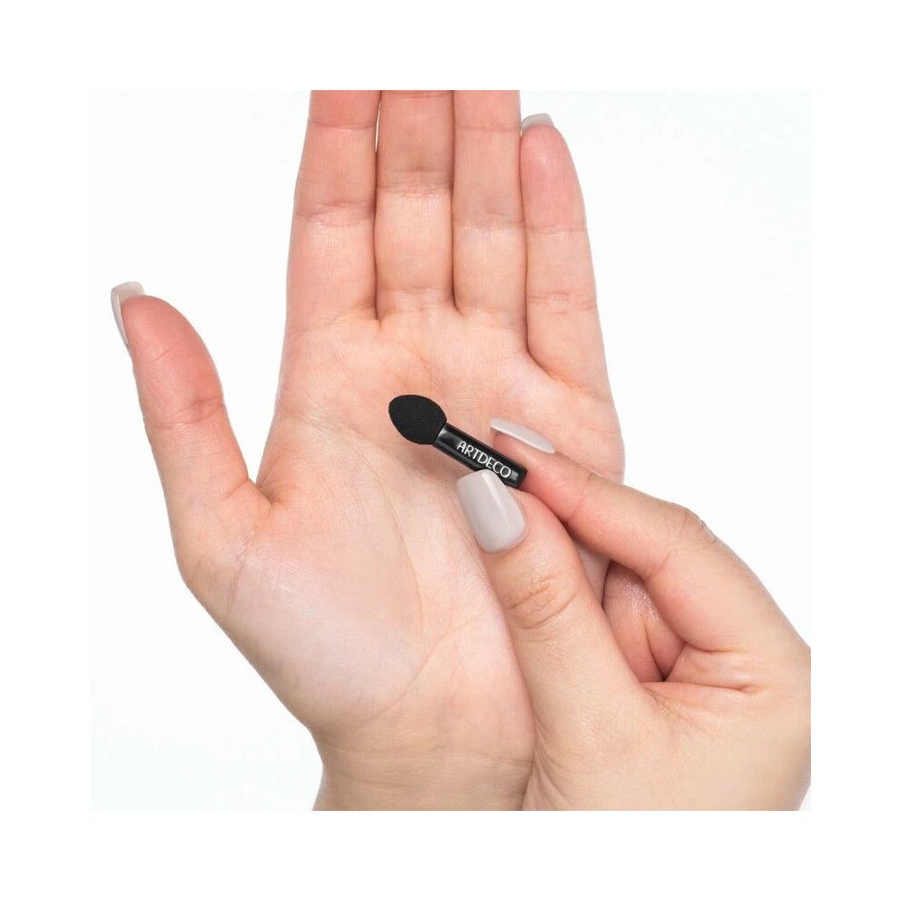 Mini Lidschattenapplikator. Schwarzer Applikator mit ARTDECO-Schriftzug. Gehalten in einer Hand.
