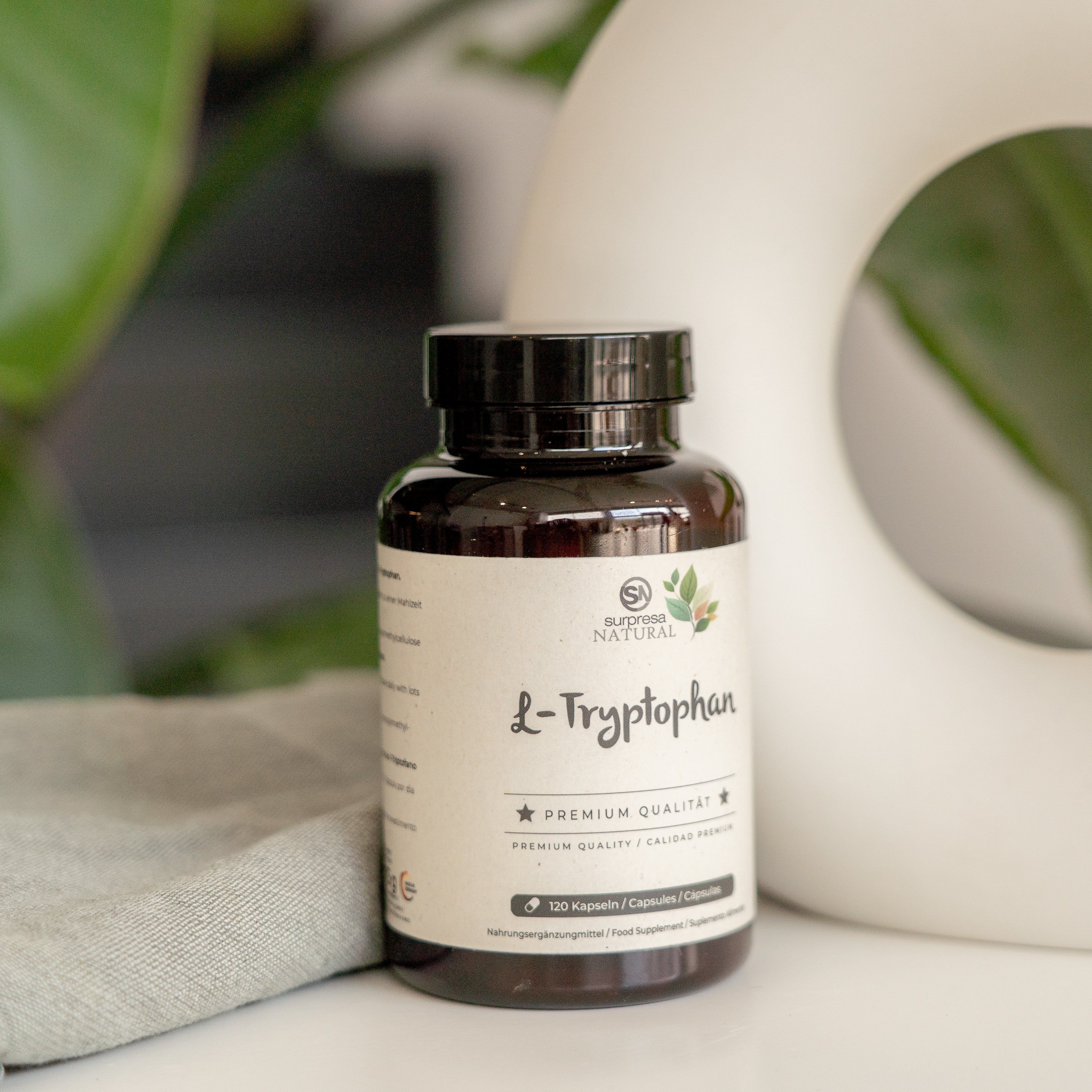 Braune Flasche mit weißem Etikett. Aufschrift: Surpresa Natural L-Tryptophan. 120 Kapseln. Premium Qualität. Steht auf einem Tisch.