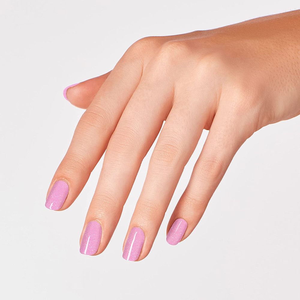 Hand mit lackierten Nägeln. Rosa Nagellack mit Glitzer.