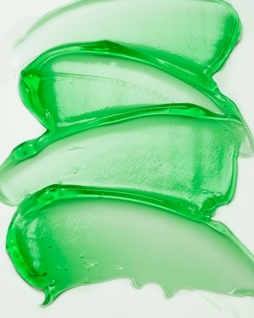 Grüne Gelspuren auf weißem Hintergrund. Die Textur ist sichtbar.