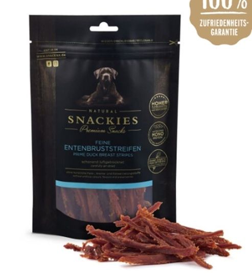 Schwarze Verpackung mit "Snackies" und "Feine Entenbruststreifen". Daneben Streifen getrockneter Entenbrust. Aufschrift: 100% Zufriedenheitsgarantie.