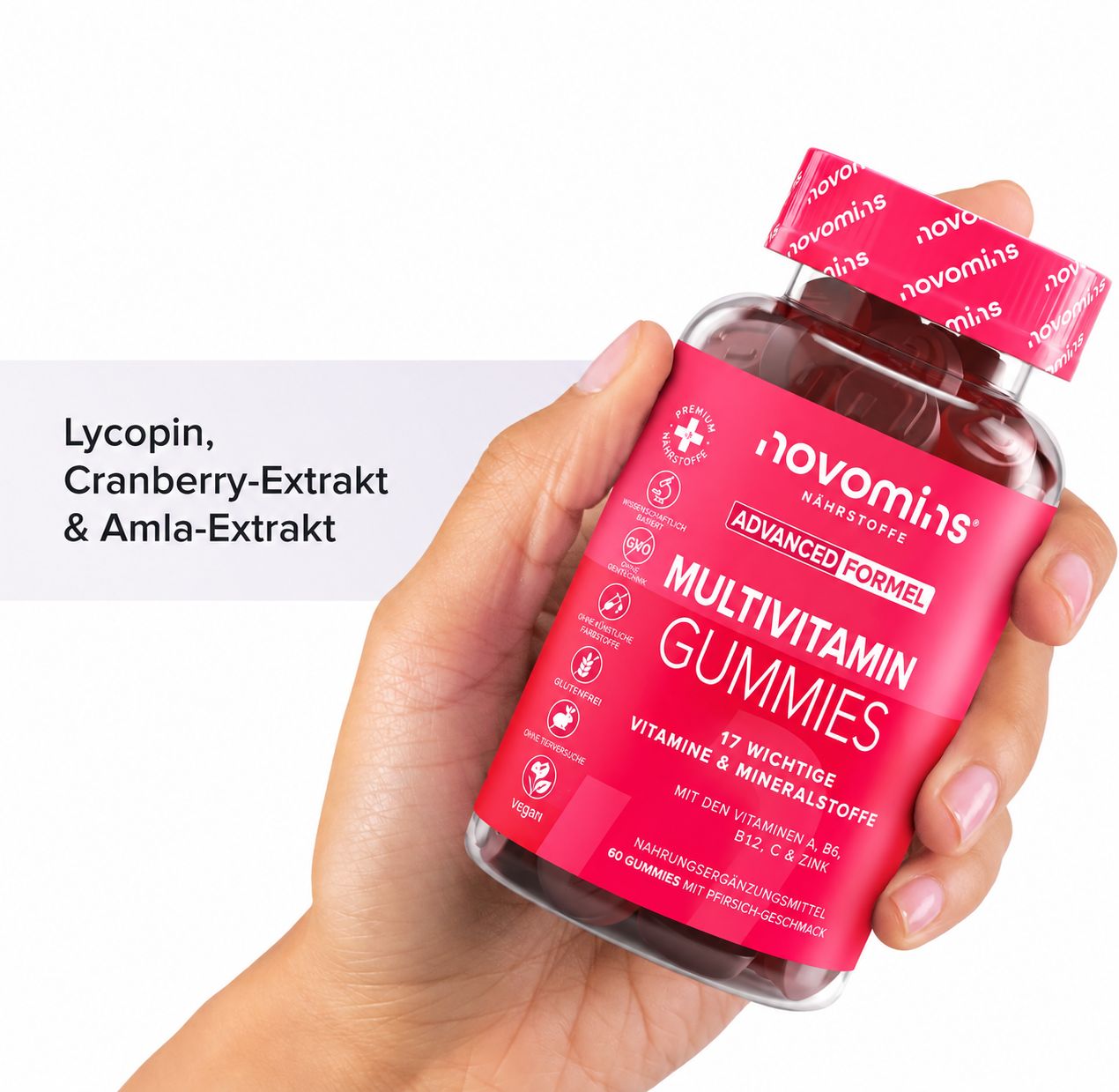 Hand hält eine Flasche "novomins MULTIVITAMIN GUMMIES" mit Lycopin, Cranberry-Extrakt.