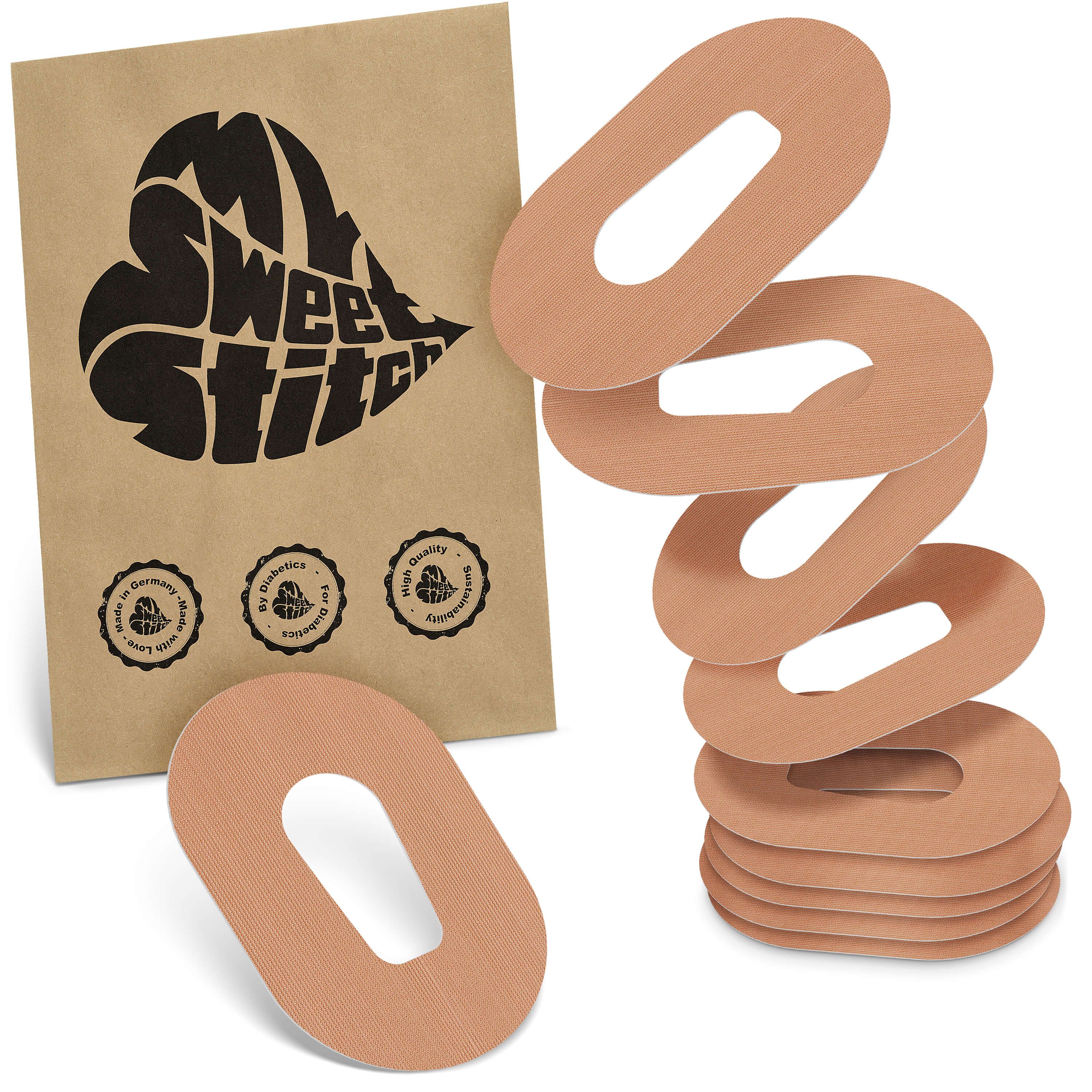 Fixierpflaster. Beige, ovales Pflaster mit Aussparung. Braune Papierverpackung mit Logo und Qualitätssiegeln.