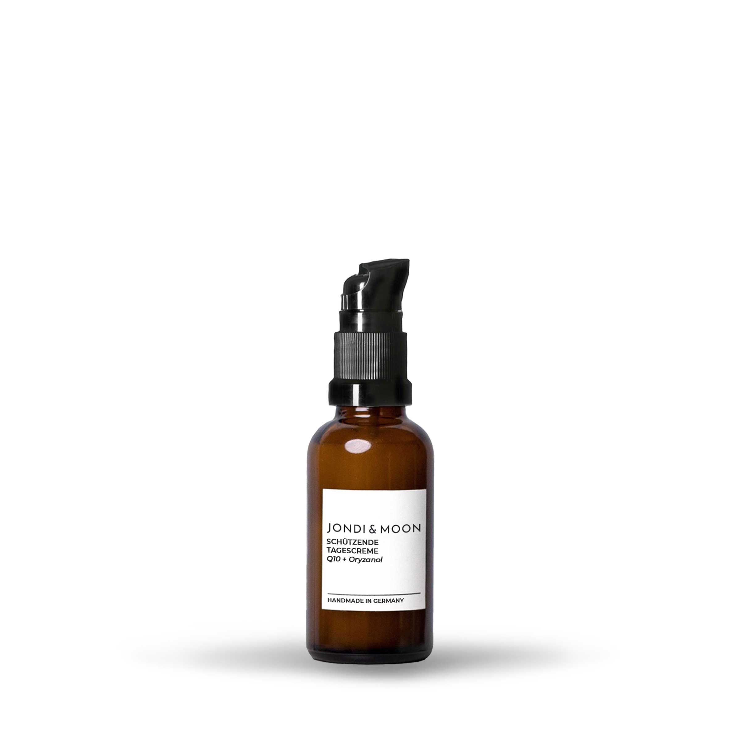 Braune Glasflasche mit schwarzem Pumpkopf. Aufkleber mit Produktinformationen. Aufschrift: JONDI & MOON, Schützende Tagescreme, Q10 + Oryzanol. Handmade in Germany.