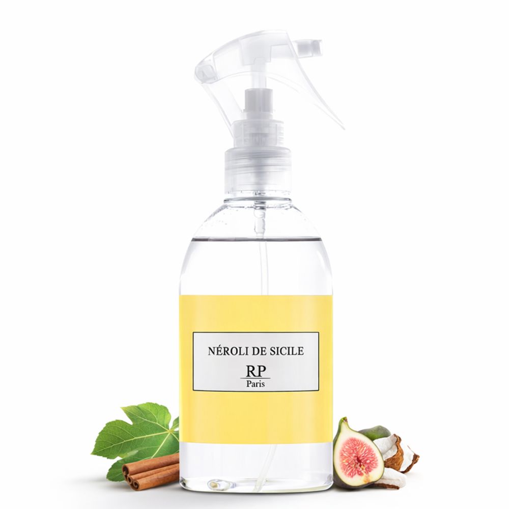Transparente Sprühflasche mit gelbem Etikett. Aufschrift: Néroli de Sicile, RP Paris. Dekoration mit Feige, Zimtstange, Blättern und Kokosnuss.