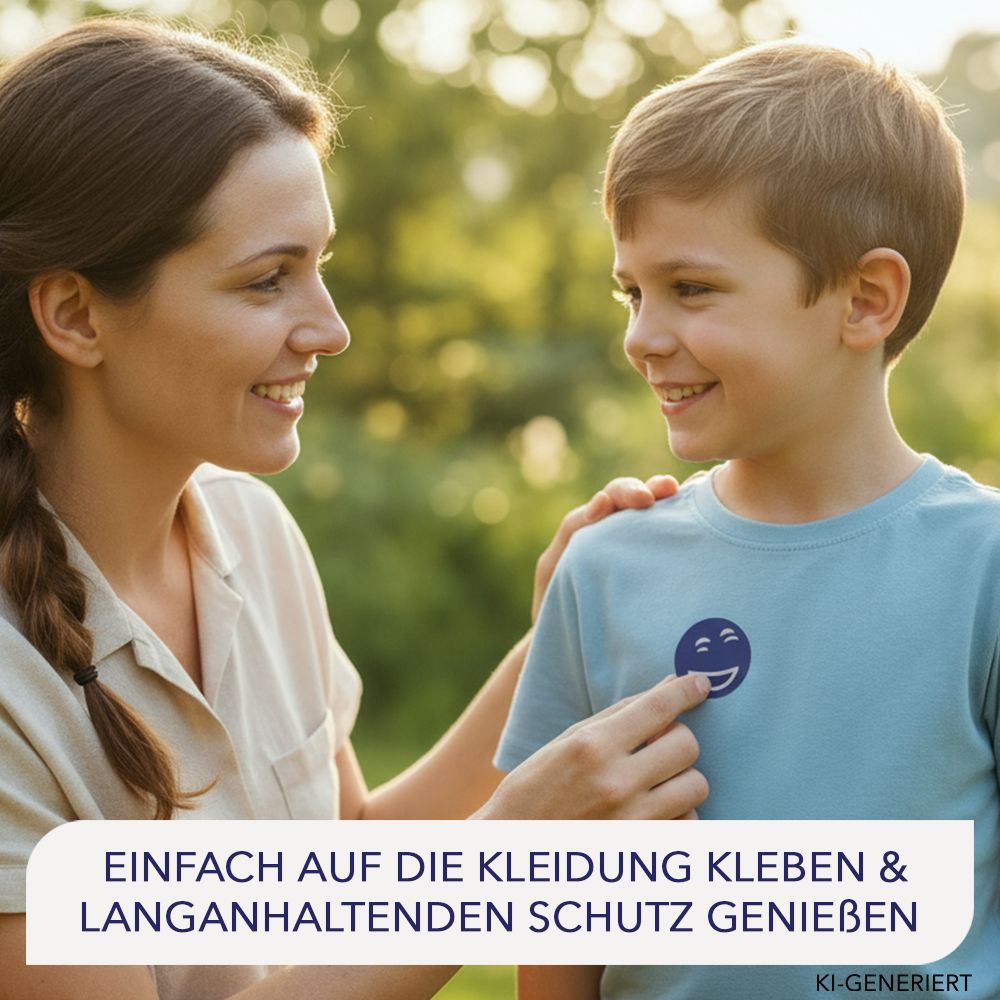 Frau zeigt einem Jungen ein Mückenpflaster mit Smiley-Motiv auf seinem T-Shirt.