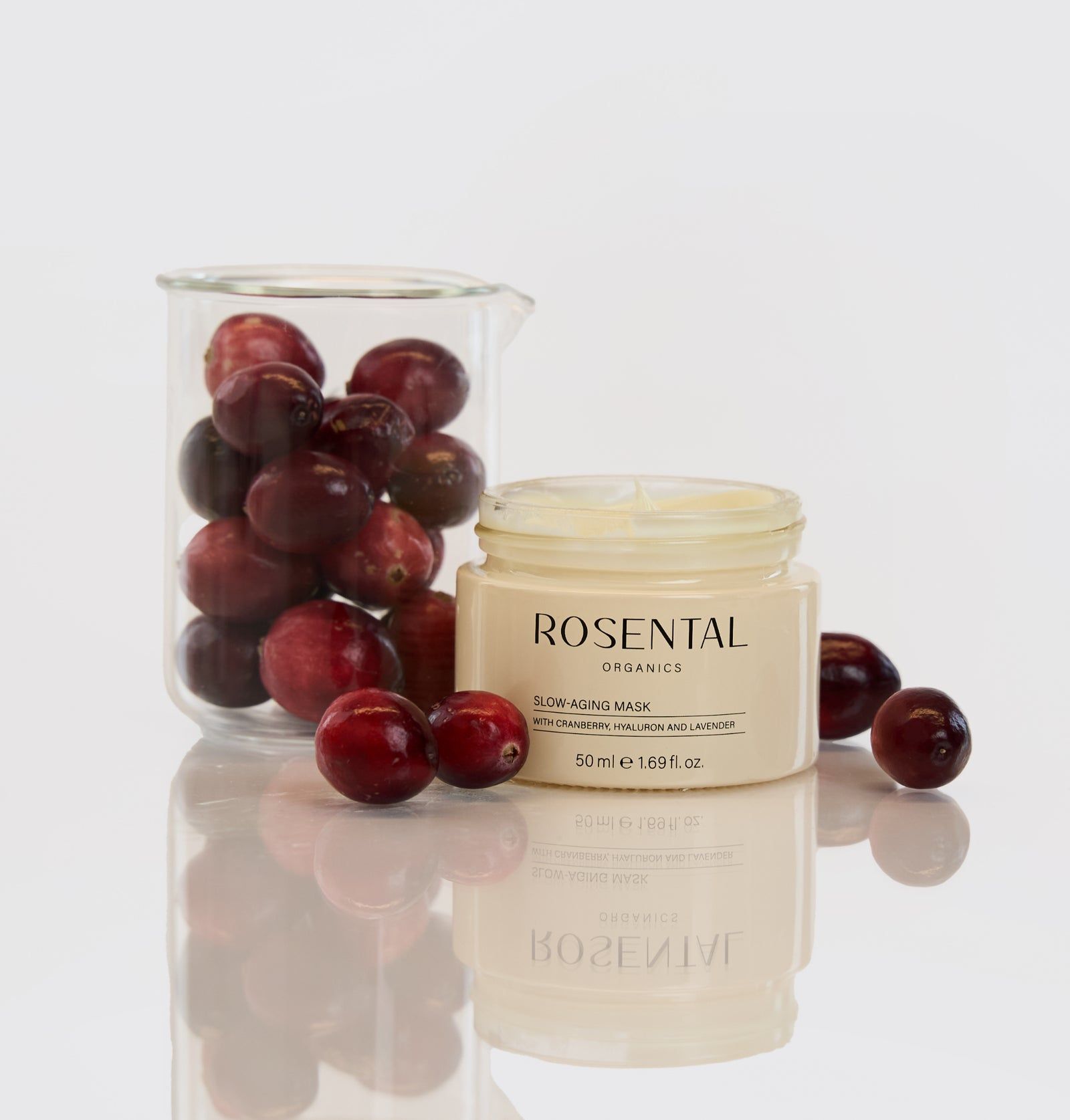 Glas mit Cranberries und ein Tiegel Rosental Organics Slow-Aging Mask. Produktname und Text auf dem Tiegel.