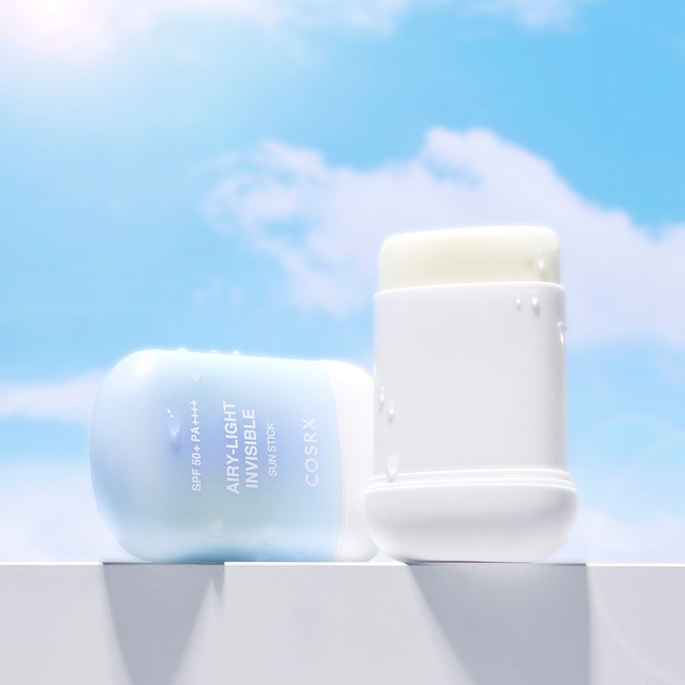 COSRX Sonnenschutzstift auf einer weißen Oberfläche vor einem blauen Himmel.