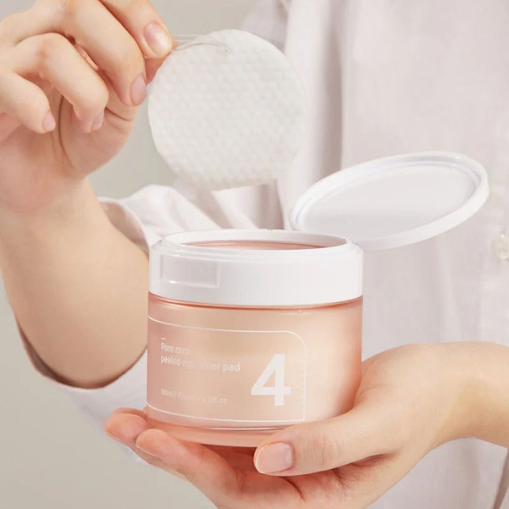 Hände halten einen Pad über einem geöffneten rosa Behälter mit weißem Deckel. Aufschrift '4'.