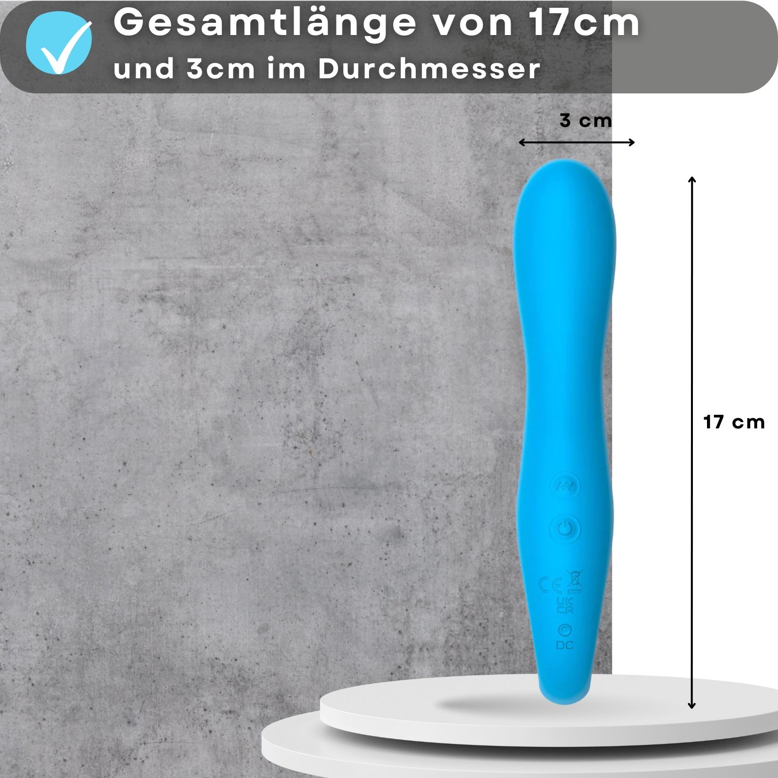 Blauer Vibrator. 17cm lang, 3cm Durchmesser. Auf Podest. Grauer Hintergrund.