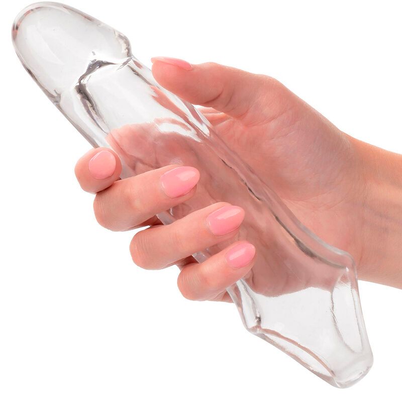 Transparente Penisverlängerung, gehalten von einer Hand. Längliche Form mit abgerundeter Spitze und Öffnung am unteren Ende.