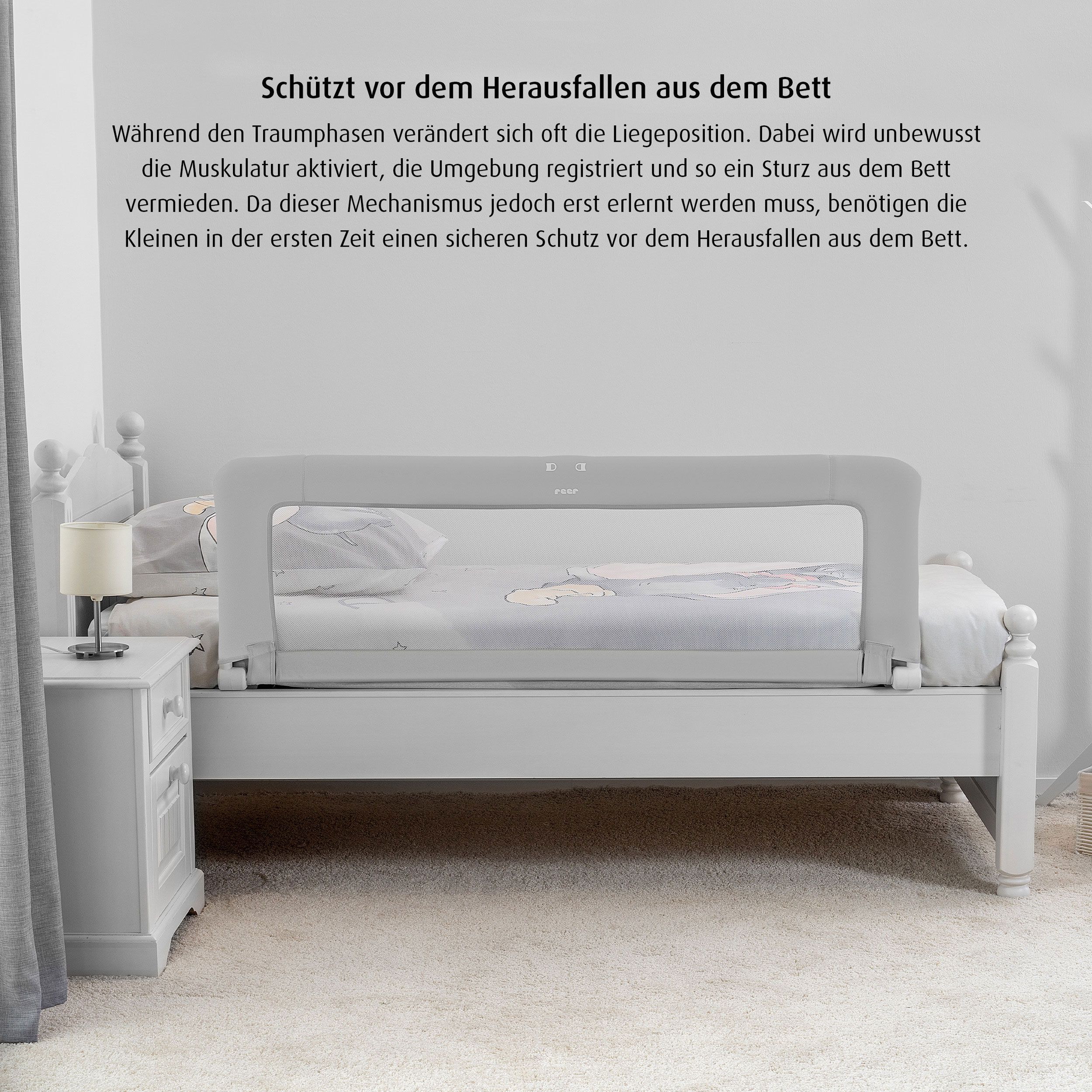 Bettgitter am Bett montiert. Grau mit weißem Netz. Marke reer. Text: Schützt vor dem Herausfallen.