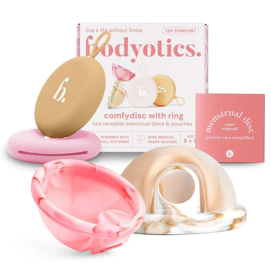Mehrere wiederverwendbare Menstruationsscheiben und Verpackung. Verschiedene Farben und Formen. Rosa Box mit Text.