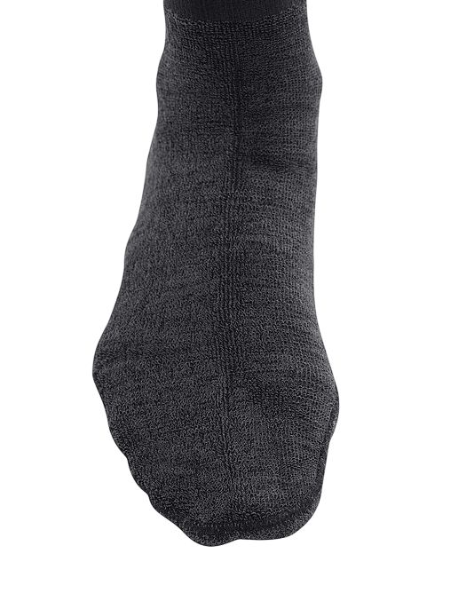 Nahaufnahme des Fußes in einem grauen Kompressionsstrumpf. Gerippte Struktur.