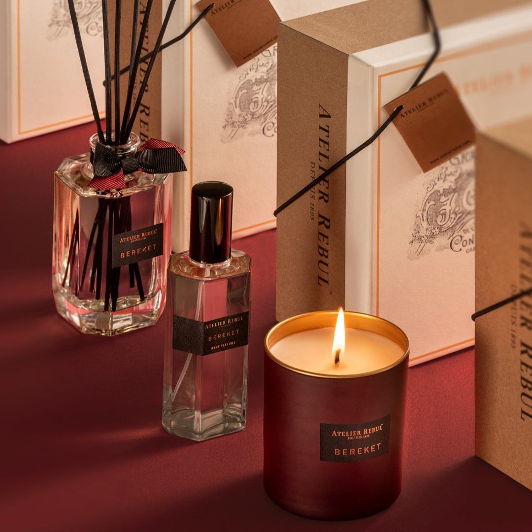 Duftkerze, Duftstäbchen und Flakon mit Etiketten. Verpackung mit Etiketten im Hintergrund.