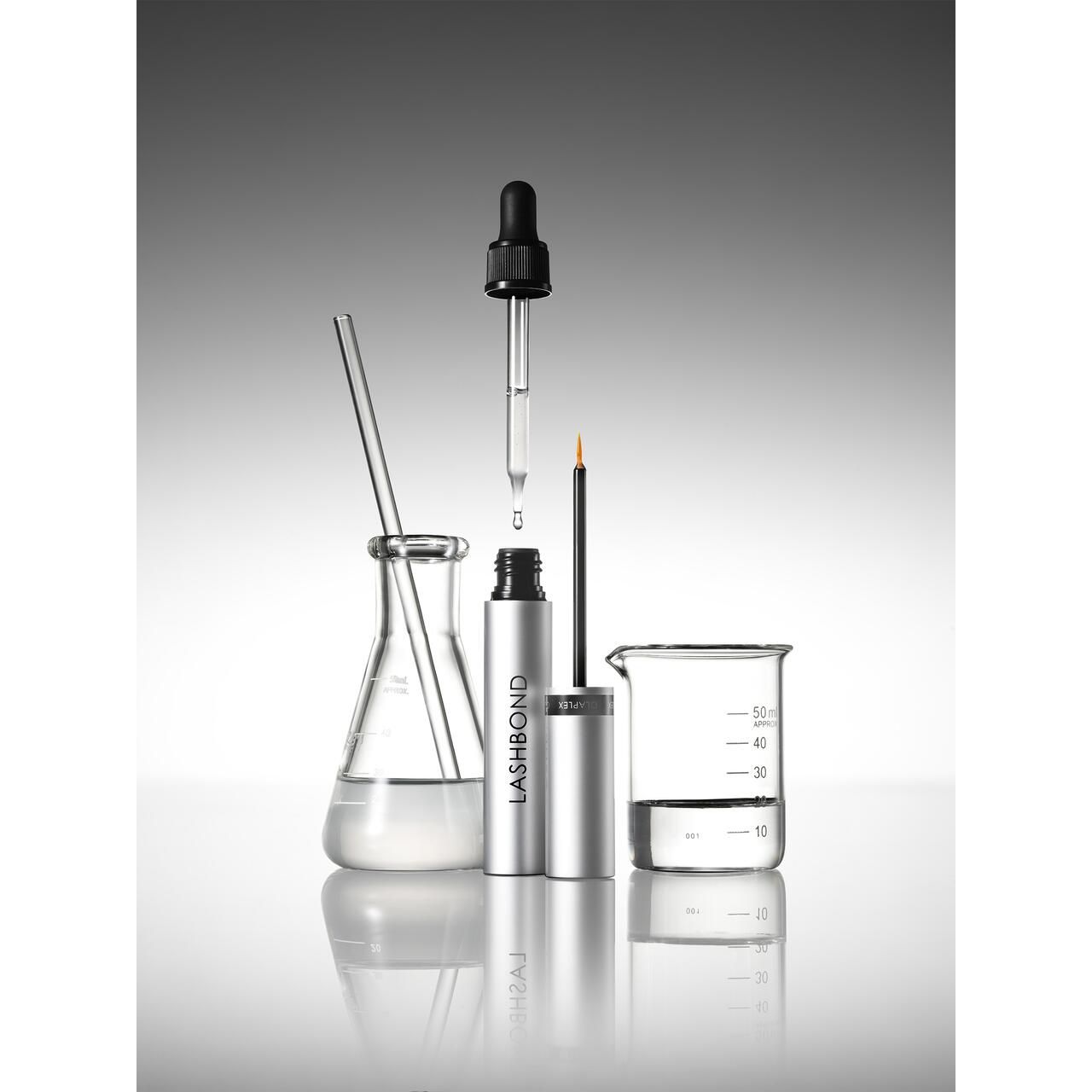 Labor-Szene mit Produkt und Laborgeräten. Das Produkt ist in einer silbernen Tube mit Applikator.