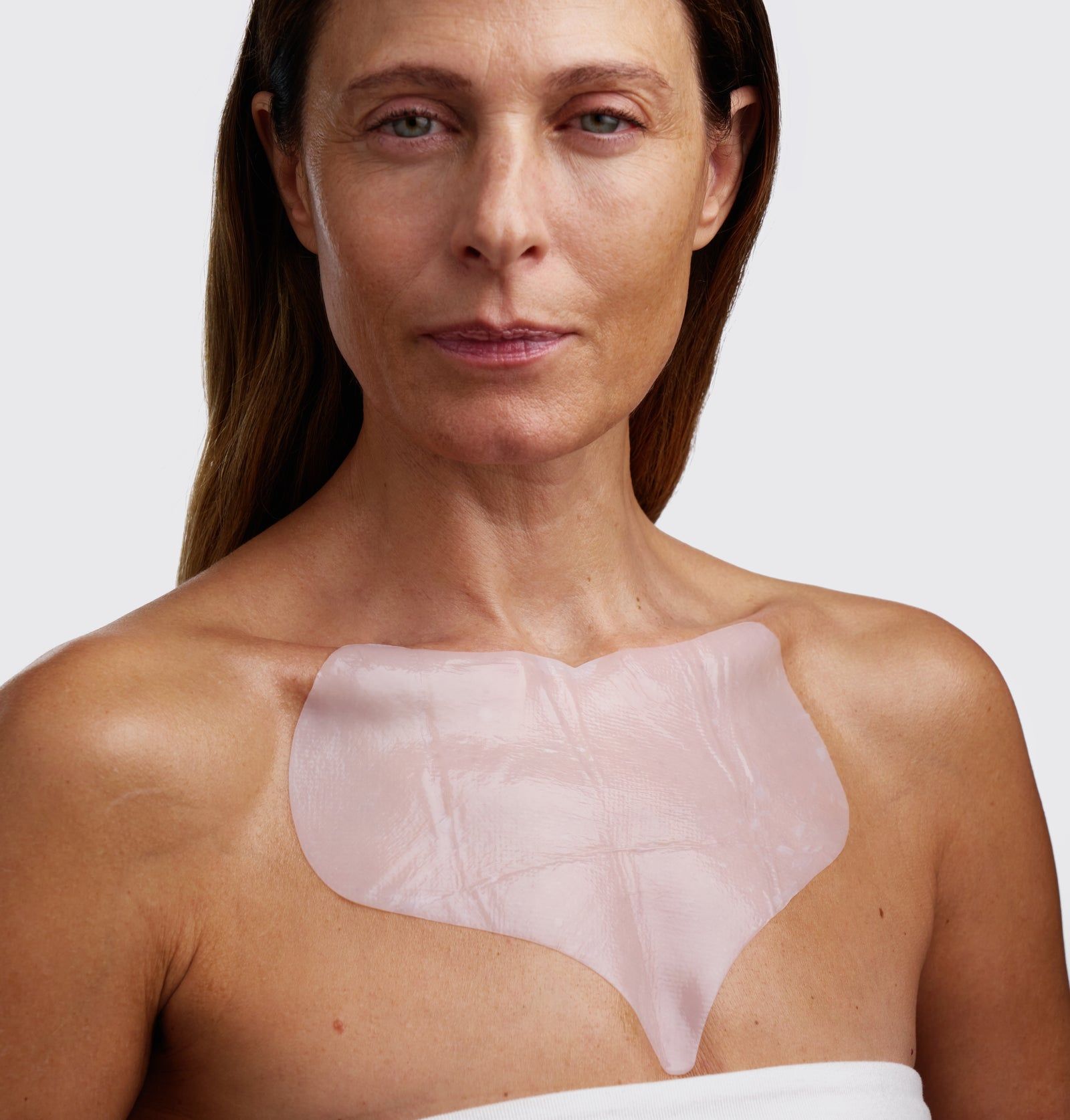 Frau mit Dekolleté-Maske. Die Maske bedeckt den Hals- und Brustbereich. Rosa, durchscheinendes Material.