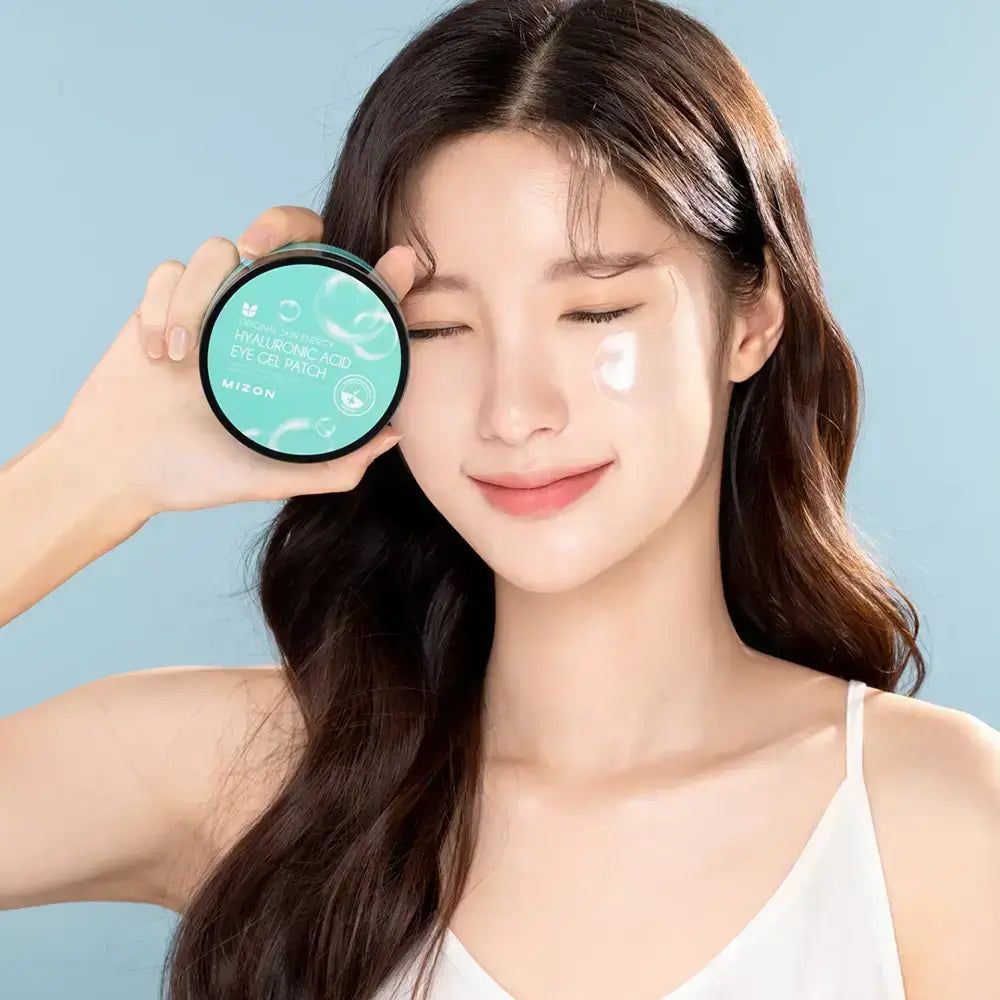 Frau hält eine Dose Augen Gel Patches. Auf der Haut ist ein Patch sichtbar. Auf der Dose steht "Hyaluronsäure Eye Gel Patch".