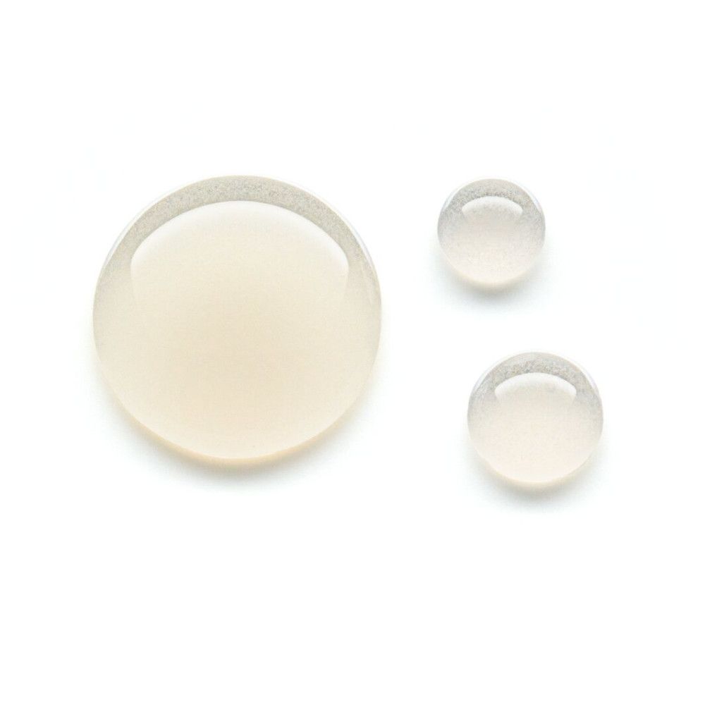 Drei Tropfen Serum auf weißem Hintergrund. Runde Form, transparente Flüssigkeit.