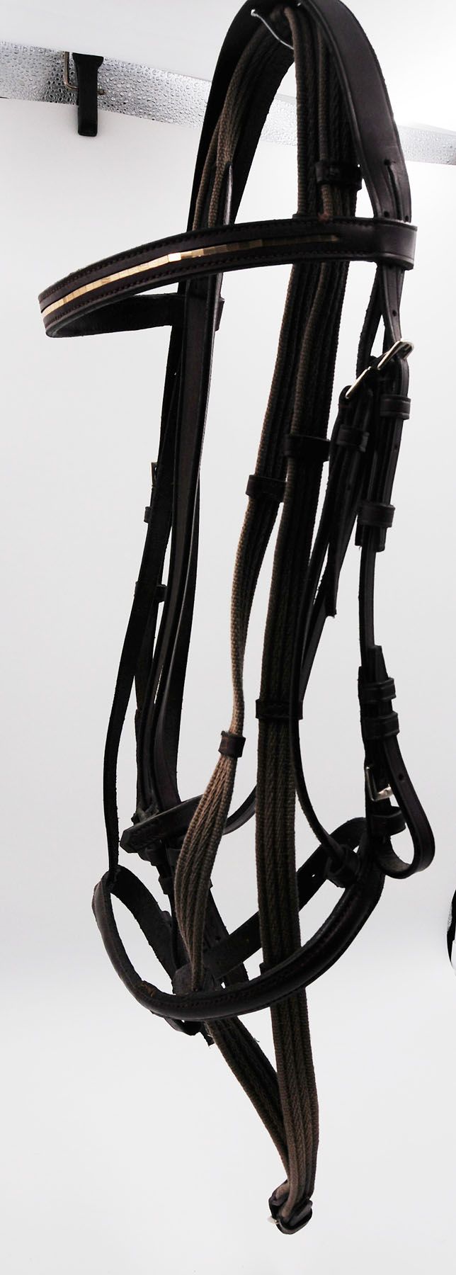 Schwarzes Zaumzeug mit braunen und grünen Details. Leder und geflochtene Elemente.