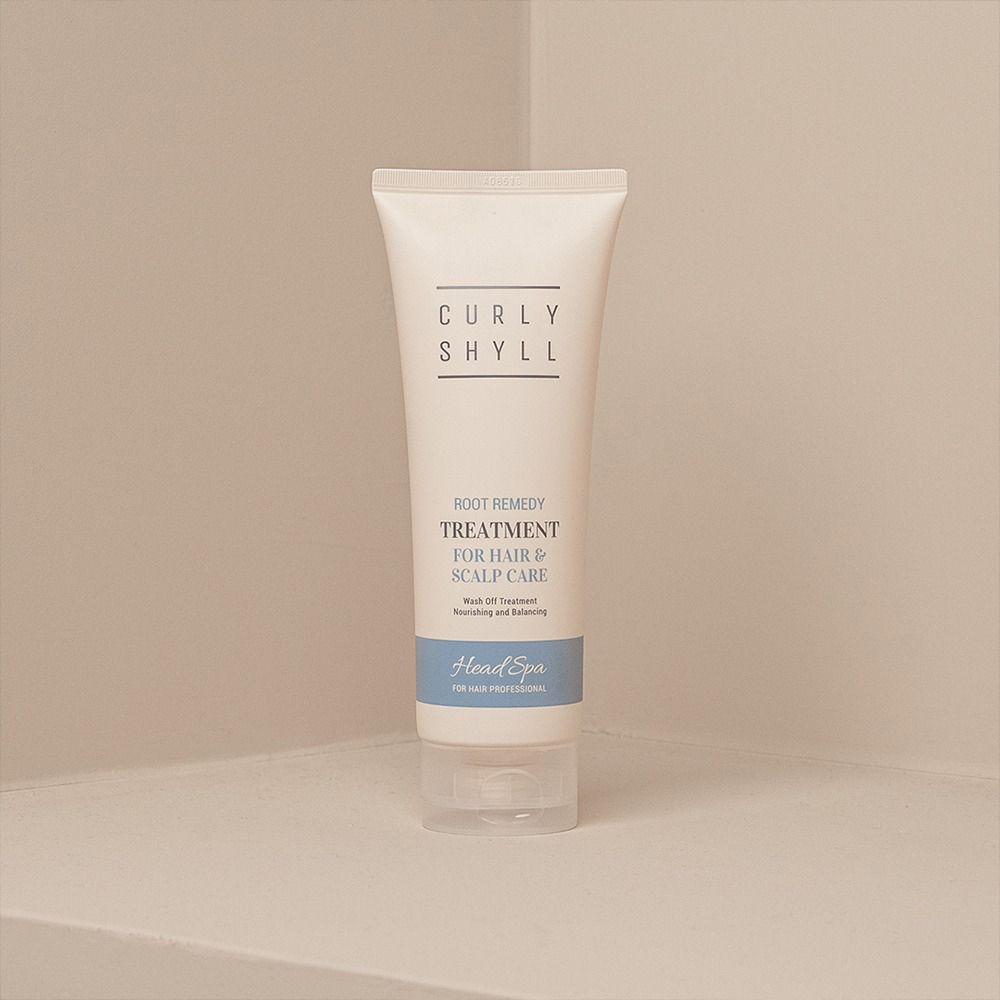 Beige Tube mit Schriftzug CURLY SHYLL, Root Remedy Treatment für Haar & Kopfhautpflege. Blaue Leiste mit Head Spa. In Ecke.