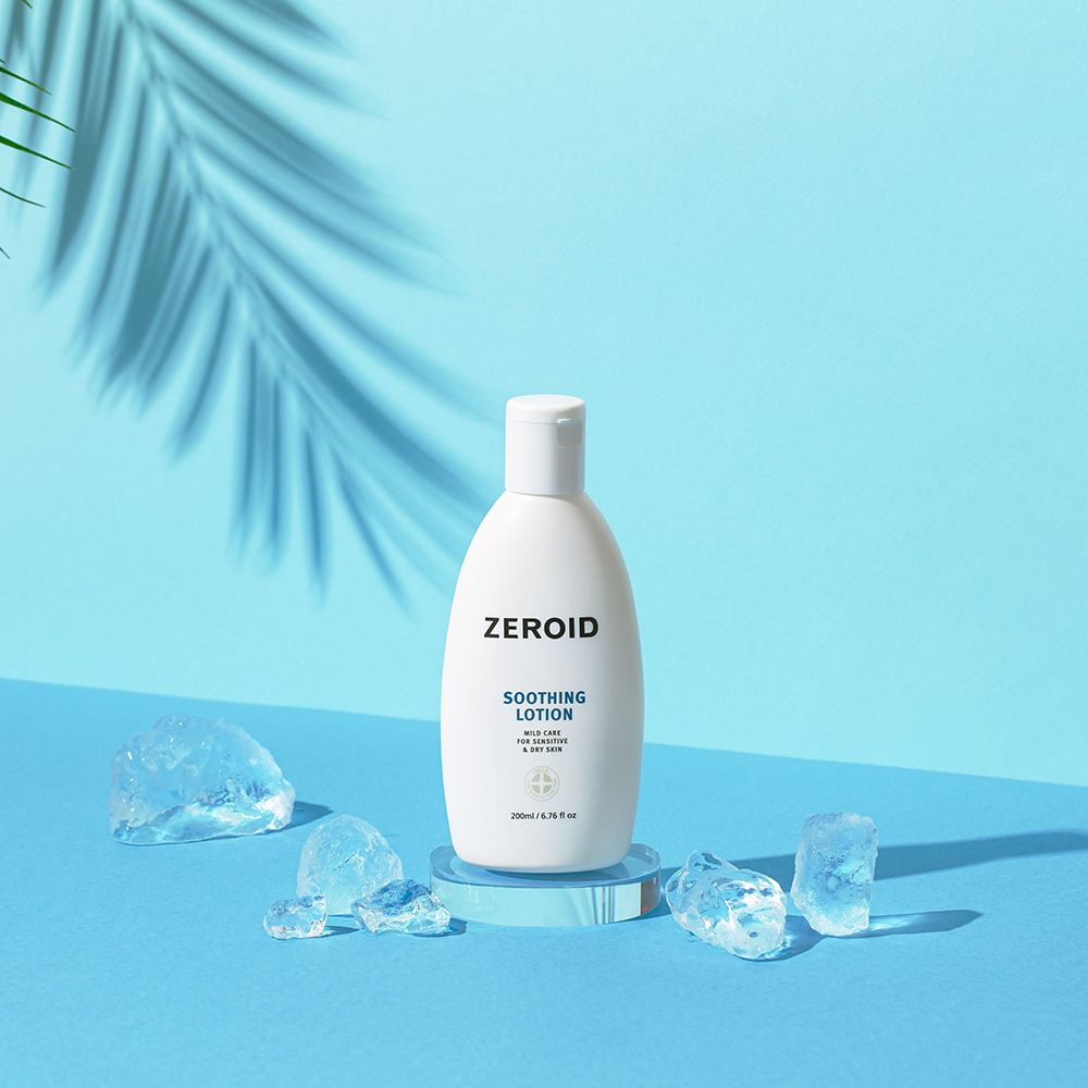 Weiße Flasche mit Klappverschluss auf Podest, umgeben von Eiswürfeln. Aufschrift: ZEROID, Soothing Lotion. Blauer Hintergrund.