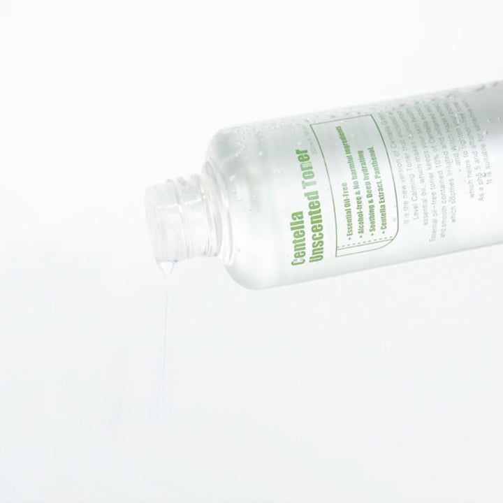 Tonerflasche, Flüssigkeit fließt heraus. Aufschrift: Centella Unscented Toner. Transparente Flasche, weißer Hintergrund.