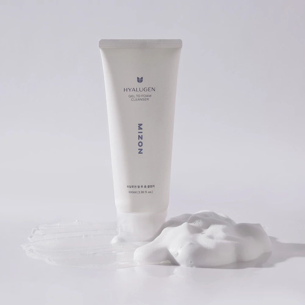 Weiße Tube mit Produkt und Schaum. Aufschrift HYALUGEN, GEL TO FOAM CLEANSER, MIZON. Schaum daneben.
