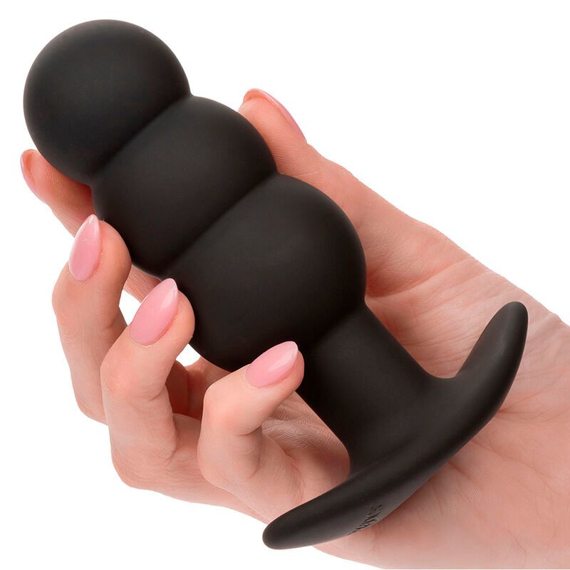 Schwarzer Analplug mit drei Perlen und T-förmiger Basis. In einer Hand gehalten.