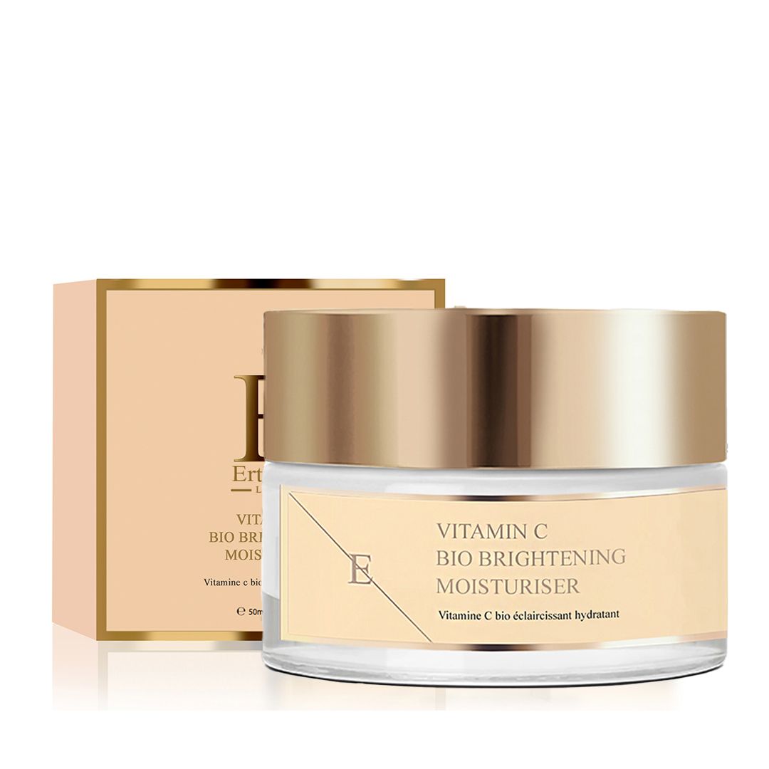 Glasbehälter mit goldfarbenem Deckel und Karton. Etikett mit Text: Vitamin C Bio Brightening Moisturiser. Marke: E.