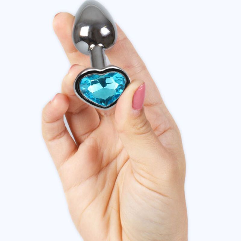 Butt Plug aus Metall mit blauem Herz, gehalten in einer Hand. Der Plug ist glänzend.