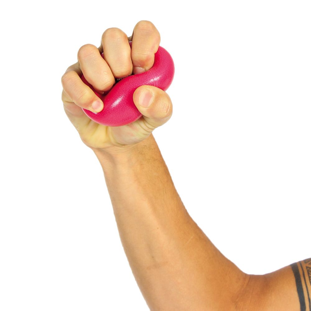 Hand, die einen pinkfarbenen Anti-Stress-Ball zusammendrückt. Der Ball ist in der Hand geformt.