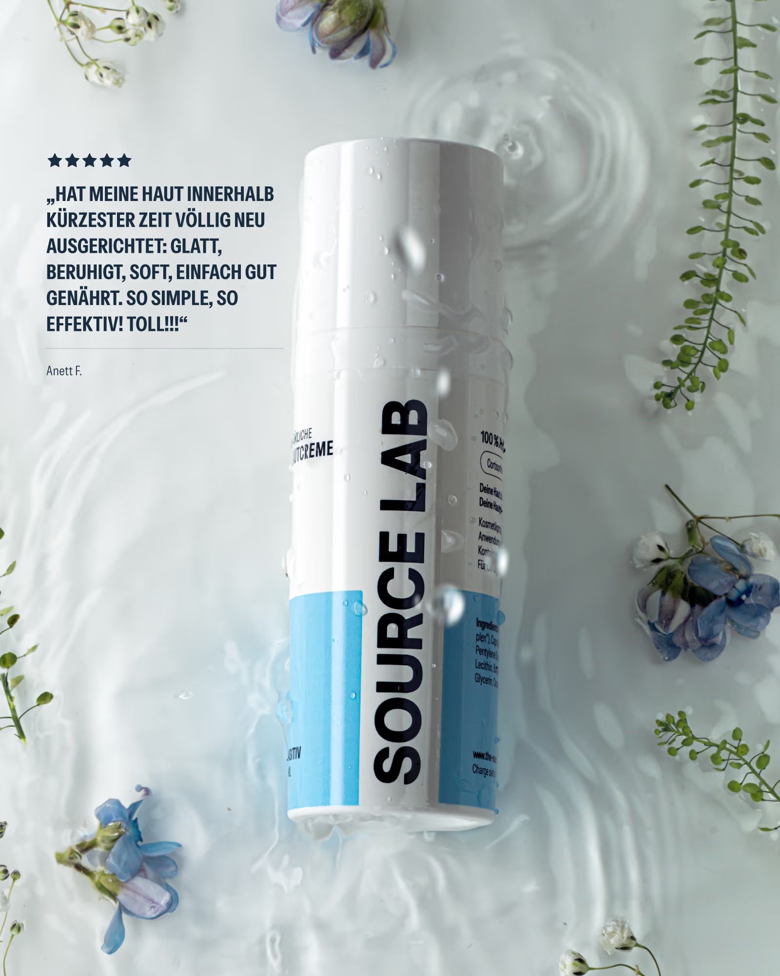 SOURCE LAB Pflegende Hautcreme Flasche umgeben von Wasser und Pflanzen.