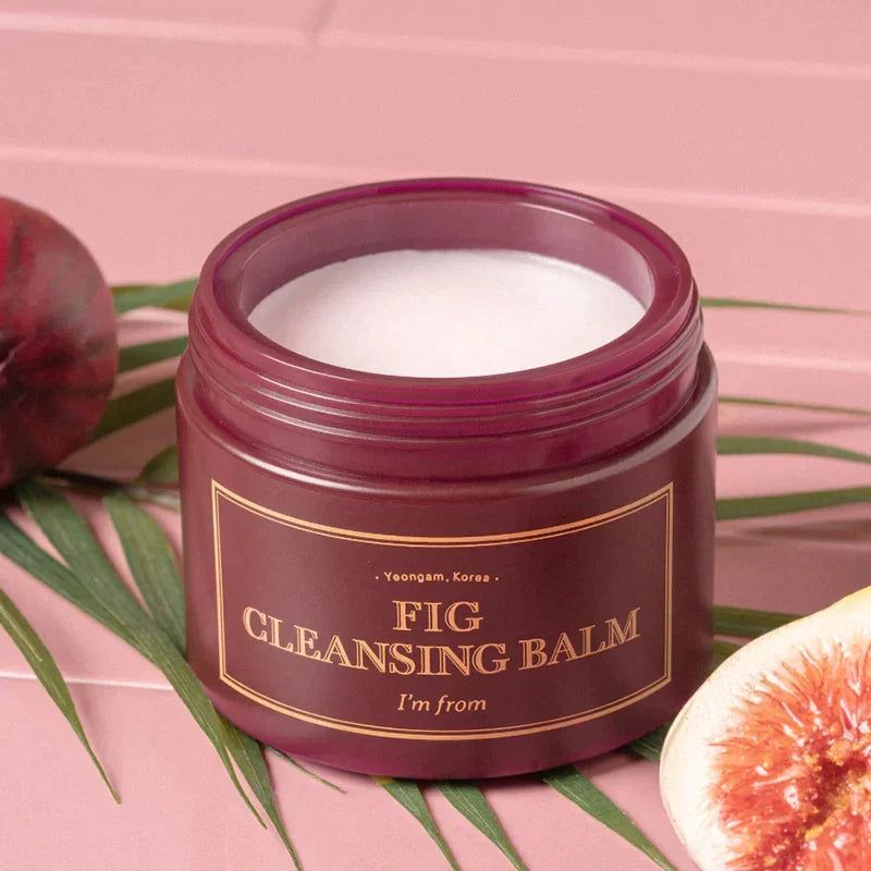 Offener, dunkelroter Tiegel mit weißem Balsam. Aufschrift: FIG CLEANSING BALM, I'M FROM. Feige und Blattwerk.