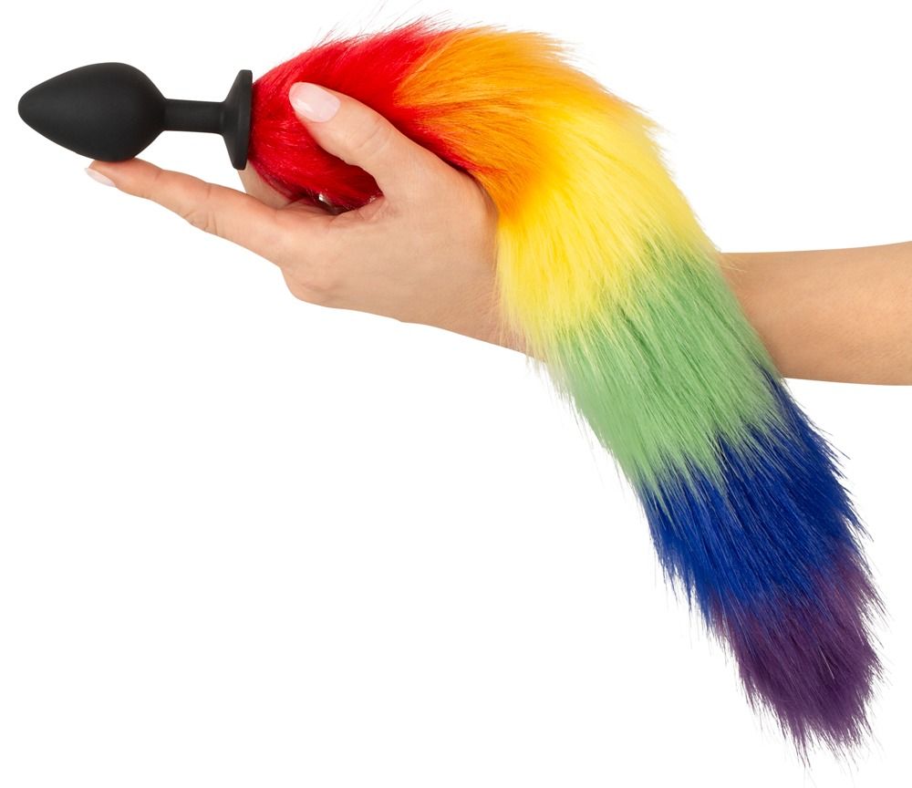 Hand hält einen Regenbogenfarbenen Fluffy Tail mit schwarzem Stecker.