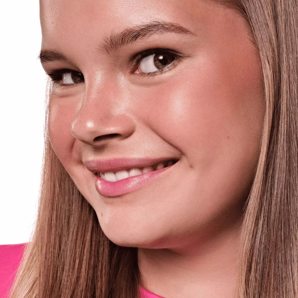 Porträt eines Mädchens mit gebräunter Haut. Rouge auf den Wangen. Rosa Lippen.