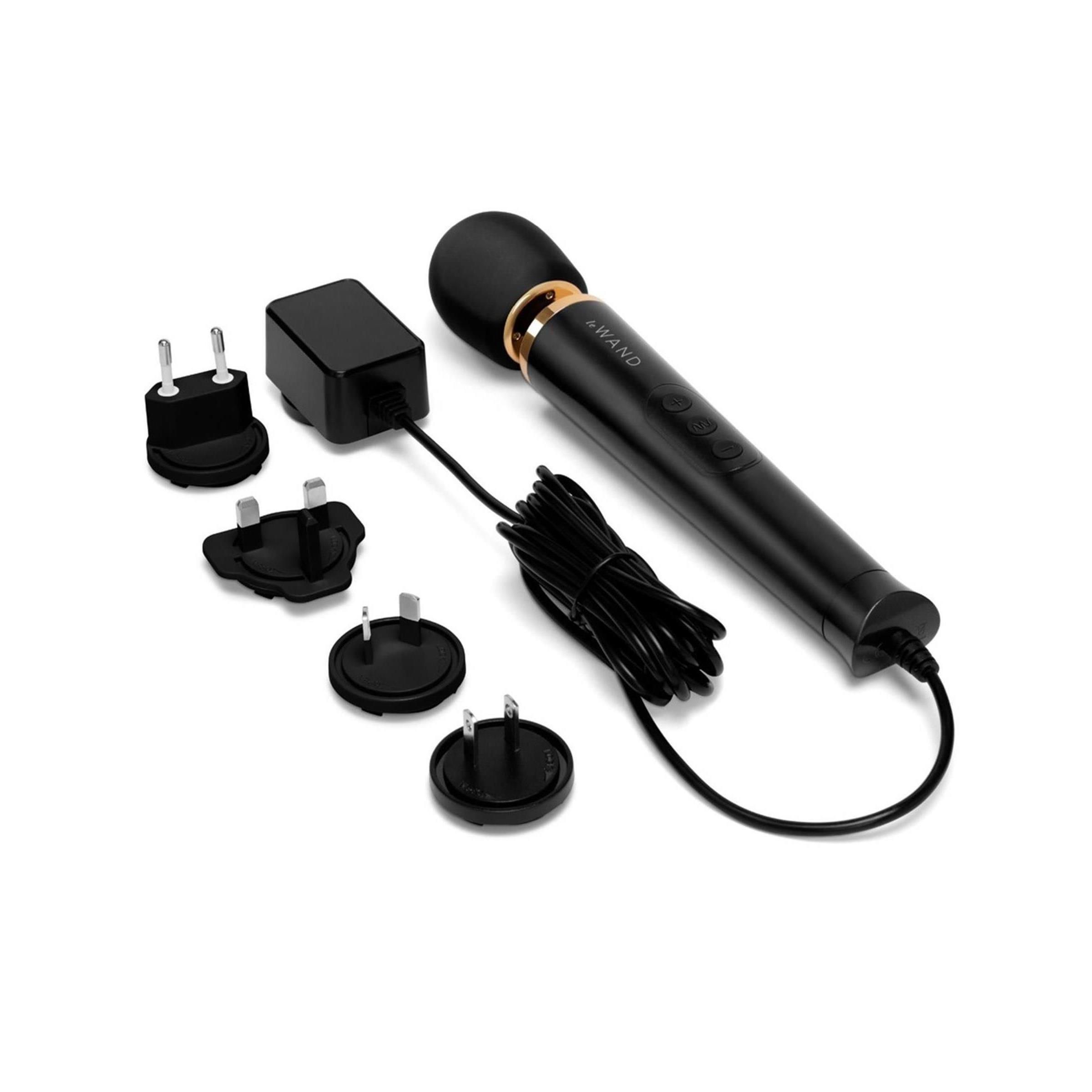 Schwarzer Massagestab mit Ladegerät und verschiedenen Adaptern. Abgerundeter Kopf, drei Knöpfe, goldfarbene Akzente.