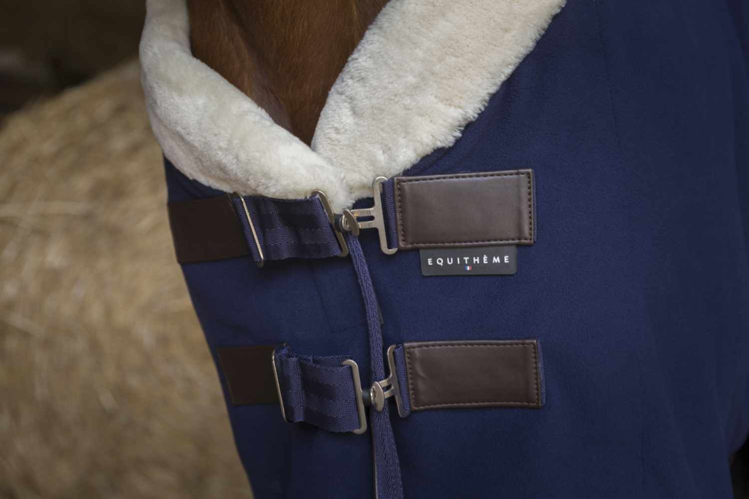 Blaue Fleecedecke mit cremefarbenem Kragen. Lederriemen mit Schnallen. Marke Equitheme.
