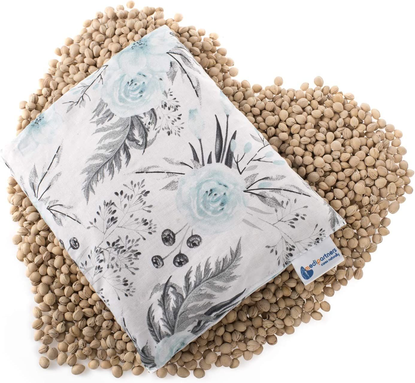 Rechteckiges Kirschkernkissen mit floralem Muster auf Kirschkernen. Blau-graue Blumen und Blätter auf weißem Stoff. Kleines Label.