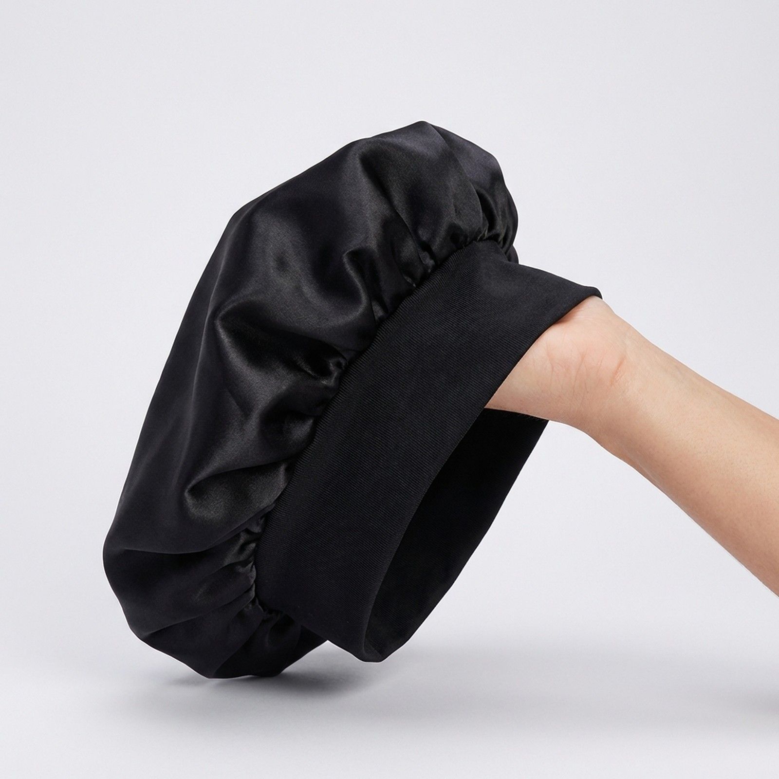 Schwarze Satin-Schlafmütze mit breitem, elastischem Bund.