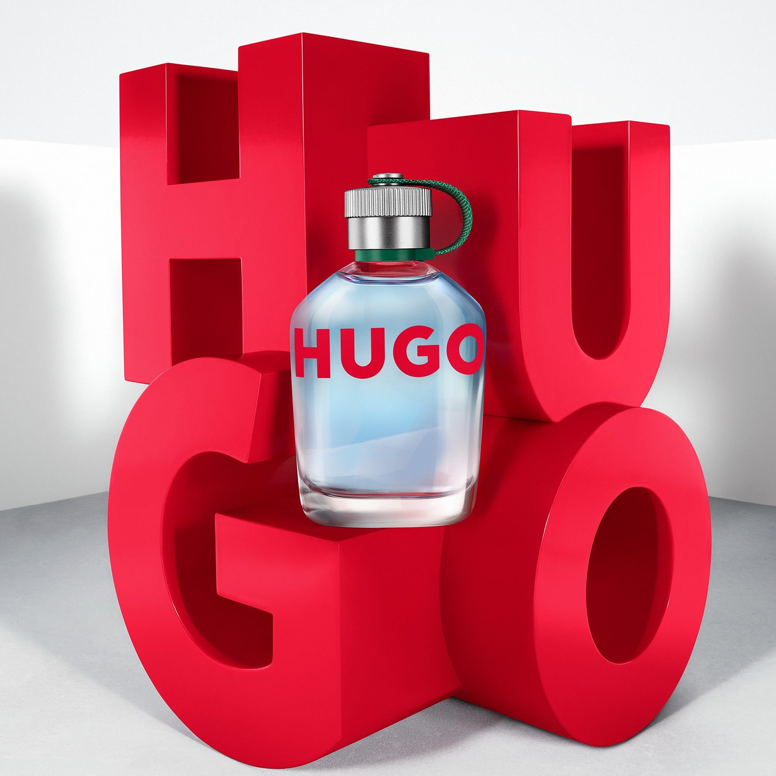 Hugo Eau de Toilette Flakon auf roten "HUGO" Buchstaben.