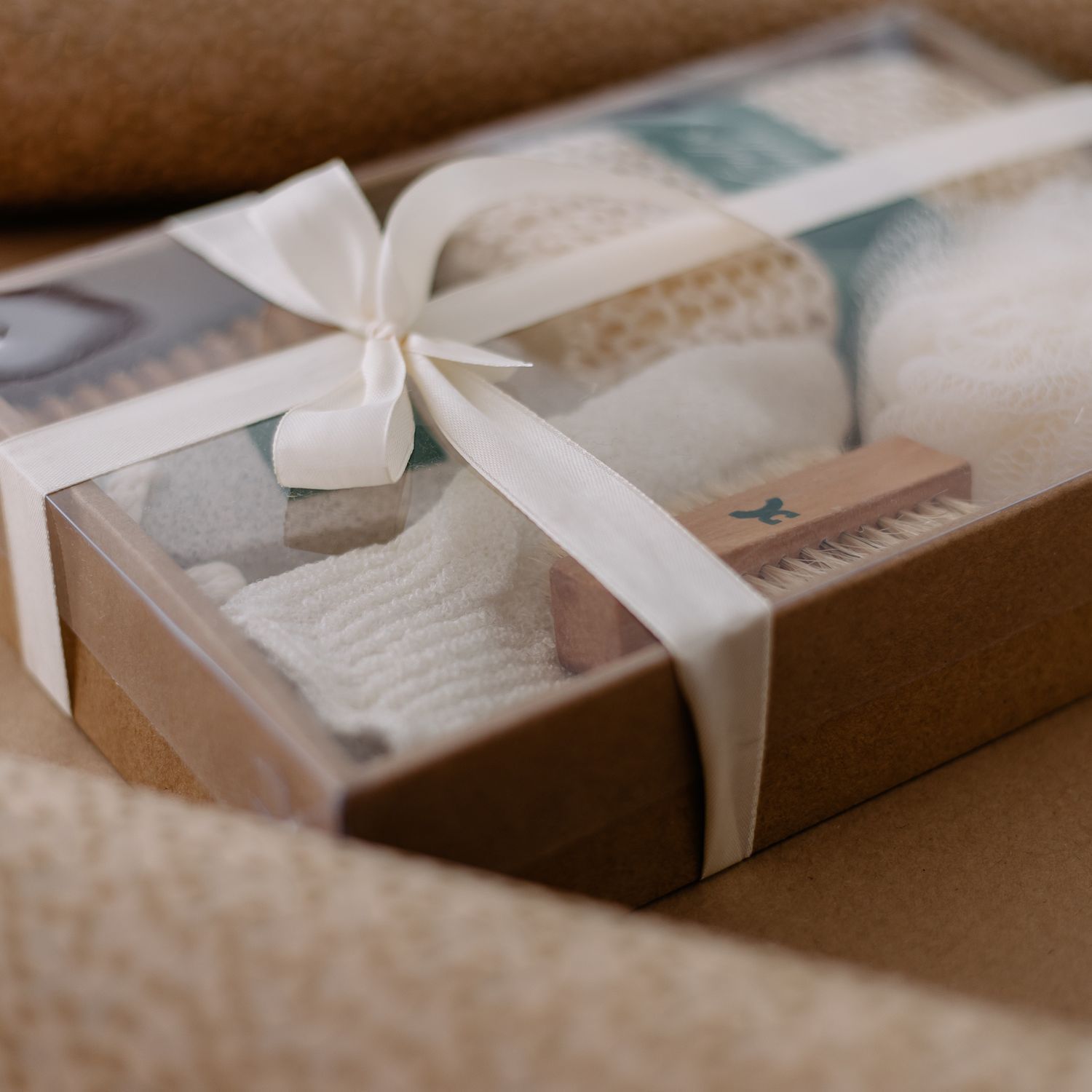Geschenkset mit Badaccessoires: Bürsten, Luffa, Handschuh und Bimsstein in einer Geschenkbox.