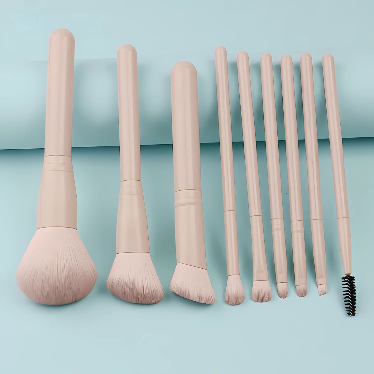 Ein Set aus acht hellbeigen Make-up-Pinseln mit unterschiedlichen Köpfen und einem spiralförmigen Bürstenaufsatz.