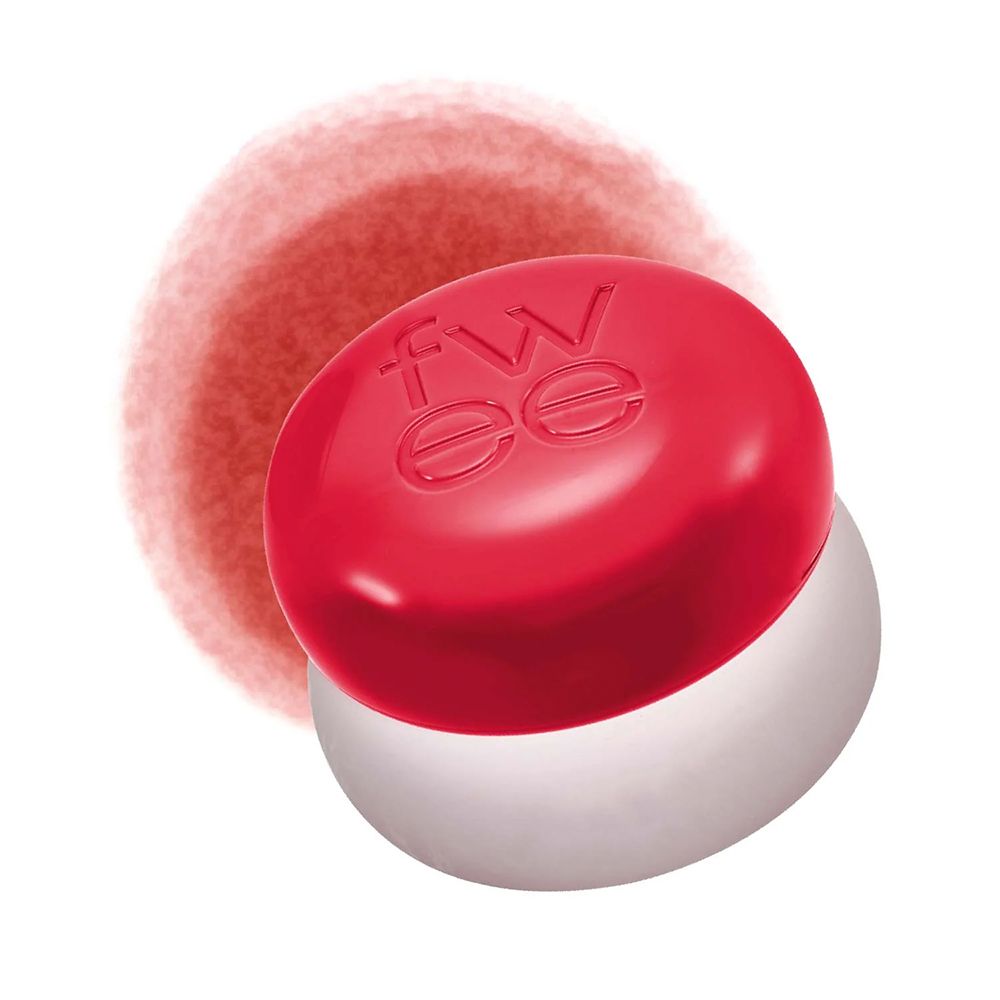 Roter Pudertiegel mit der Aufschrift "fwee" neben einem roten Farbfleck.