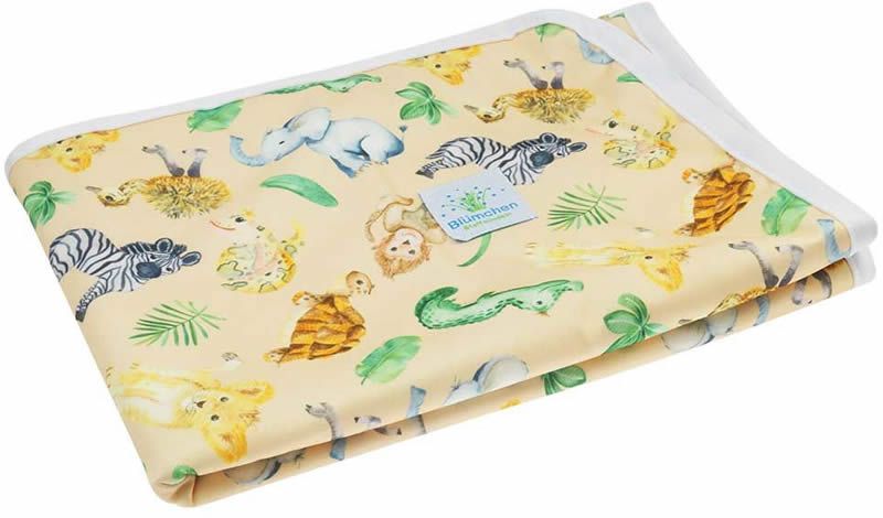 Wickelunterlage mit Tiermuster. Gelber Stoff mit Elefanten, Zebras und Löwen. Weißer Rand. Label mit Logo.