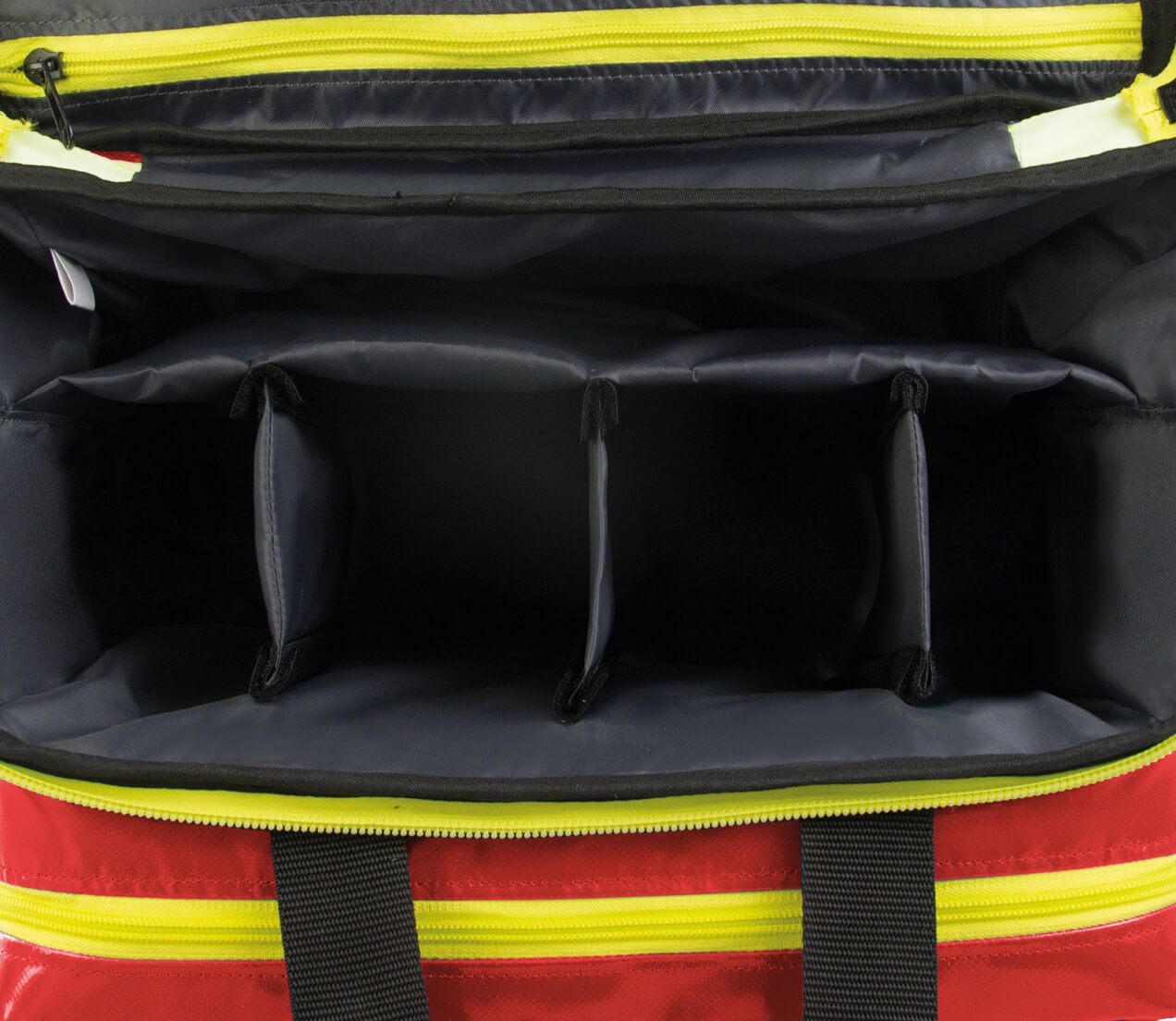 Nahaufnahme der Innenaufteilung einer roten Notfalltasche. Vier Fächer sind sichtbar. Gelbe Reißverschlüsse.