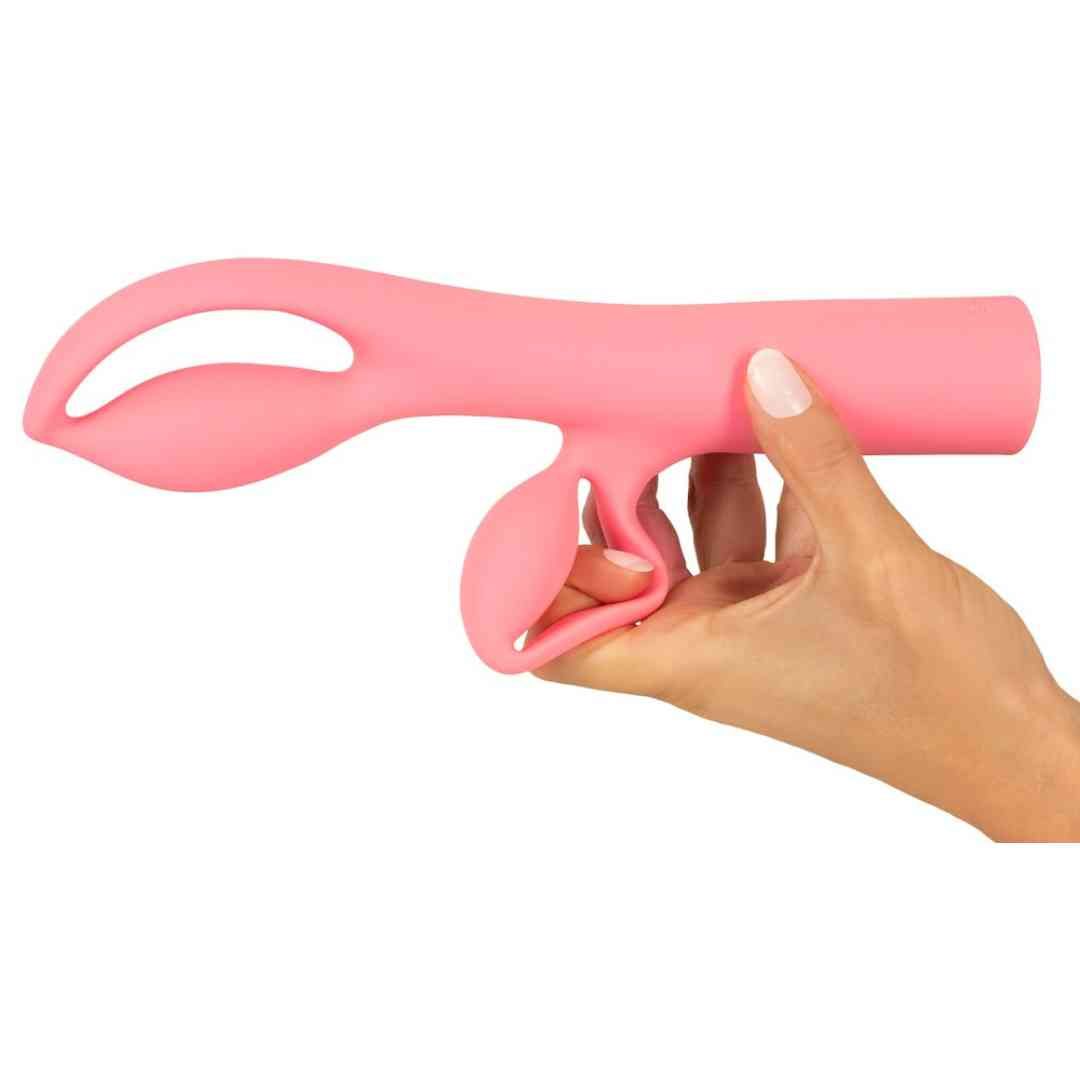 Rosa Vibrator, gehalten in einer Hand. Das Design hat zwei abgerundete Enden und einen länglichen Schaft.
